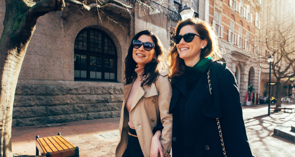 Two Women Walking Outdoors And Smiling